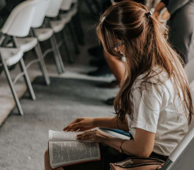 Jeune femme lisant un livre à une conference